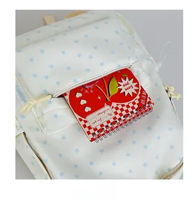 Detailed view of the front zipper pocket on a white star print canvas backpack with books