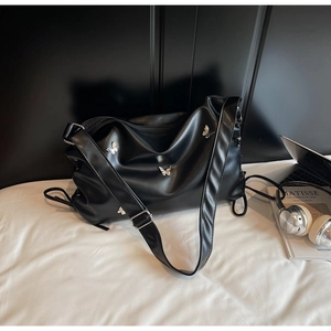 Détail du sac hobo en PU noir mat avec papillons argentés en 3D et bandoulière