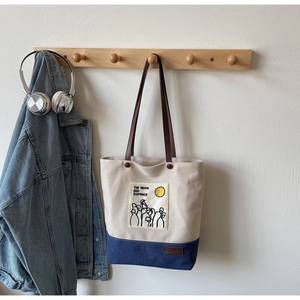 Detail of color-block canvas tote bag featuring The Moon and Sixpence illustration design