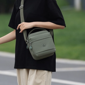 Détail de la sacoche en nylon vert militaire avec fermetures éclair et logo en métal