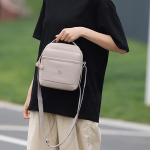 Photo en plein air d'un sac à main beige tendance avec finition texturée et logo ms