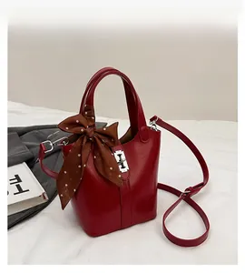 Dettagli della borsa a secchiello rossa con foulard in seta e chiusura girevole argento