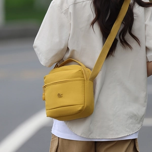 Vue de dos extérieure d'un sac bandoulière jaune moutarde montrant sa taille et sa sangle
