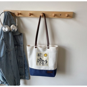 Detailed view of the Moon and Sixpence canvas tote bag showing contrast stitching and handles