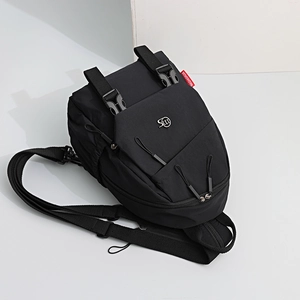 Detail of black oxford nylon backpack with secure plastic buckles and metal logo