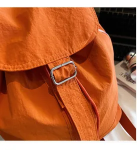 Détail macro du tissu ripstop orange imperméable avec boucle de réglage en métal argenté