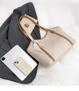 Top view of large tote bag showing capacity with tablet and scarf detail on bed