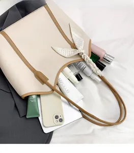 Detail view of spacious beige tote bag interior with cosmetics and silk scarf decor