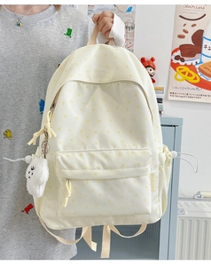 Detail of beige star pattern canvas backpack with plush charm and drawstring pockets