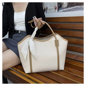Detail of off-white lychee leather tote bag with camel trim and a plaid silk scarf