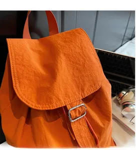Gros plan d'un sac à dos en nylon orange imperméable avec une boucle en argent massif