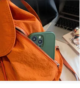 Détail de la poche latérale zippée sur sac à dos en nylon orange montrant sa capacité
