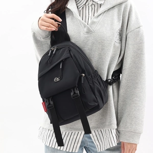 Detail of black nylon backpack featuring secure buckle closure and adjustable strap