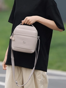 Sac bandoulière beige minimaliste avec sangle réglable et logo pour l'usage quotidien