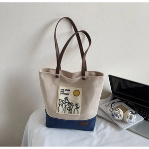 Detail of canvas tote bag with contrast denim base and The Moon and Sixpence illustration