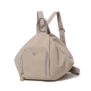 Detail view of khaki waterproof nylon backpack showing front zip pocket and logo