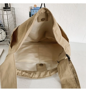 Detail of khaki nylon tote interior showing large capacity and magnetic snap closures