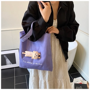 Detail of purple canvas tote bag featuring a cute 3D plush animal and open top design