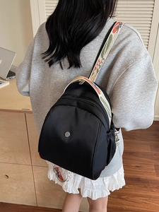Mini zaino nero con spalline jacquard colorate in un moderno ambiente da ufficio