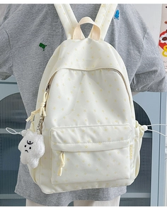 Close-up of beige backpack with star prints and a cute plush star pendant accessory