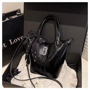 Dettaglio borsa a secchiello nera lucida con foulard a pois in confezione regalo