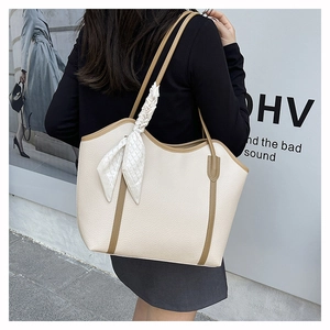 Detail of cream tote bag with contrast brown trim and geometric silk scarf detail