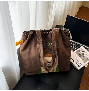 Detail of embroidered bear and Sleepy text on large brown canvas tote bag with drawstring