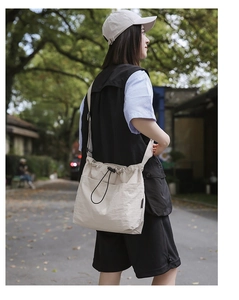 Detailed view of beige nylon bucket bag featuring a drawstring closure and wrinkled texture