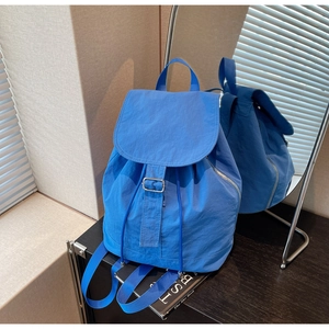 Vue latérale détaillée d'un sac à dos en nylon bleu imperméable avec fermeture éclair latérale