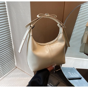 Gros plan du sac hobo crème montrant la texture en cuir PU et le détail du nœud décoratif