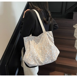 Detail of white floral lace tote bag with orange flower lining and shoulder strap