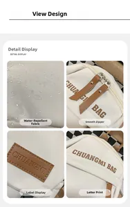 Detail view of water-resistant fabric, smooth zipper, and leather logo on the cream bag