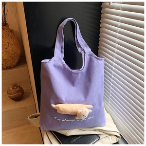 Detail of light purple canvas tote bag with a cute 3D plush cat and white embroidery
