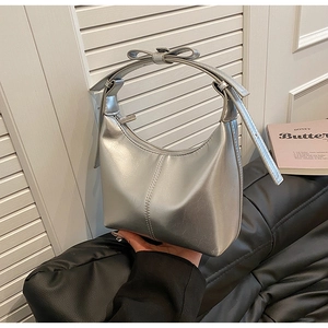 Gros plan du sac hobo argenté en similicuir métallisé avec détail de nœud sur la poignée