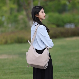 Outdoor shot of a beige large-capacity casual backpack with adjustable wide straps