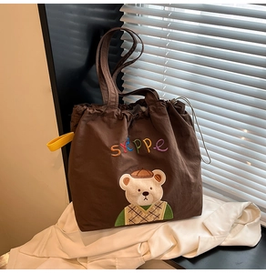 Close-up of cute bear embroidery and STEPPe lettering on large canvas tote bag