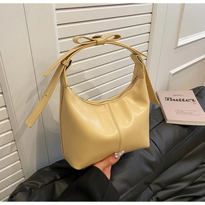 Détail du sac hobo en cuir crème avec bandoulière à nœud et finition plissée élégante