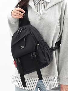 Compact black nylon backpack for women showing multi-layer zippers and side buckle pocket