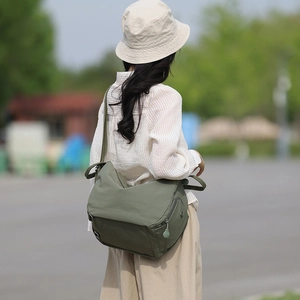 Army green nylon crossbody bag showing spacious main flap and adjustable strap detail
