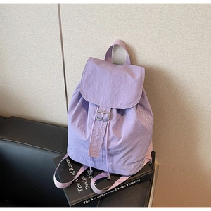 Détail macro du sac à dos en nylon lilas avec fermeture à rabat et boucle coulissante