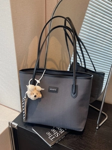 Large dark grey chevron tote bag with shoulder straps and plush bear charm for daily commuting