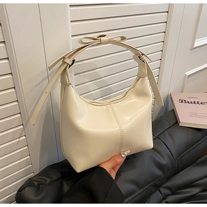 Détail du sac demi-lune blanc cassé avec bandoulière à nœud et détails de double couture