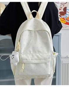 Detail of off-white star pattern backpack with plush charm and functional side pockets