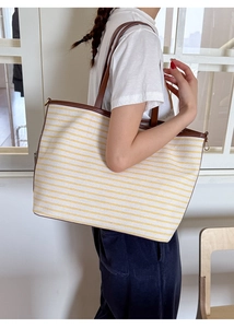 Lifestyle shot of large yellow striped canvas tote bag with brown leather straps