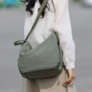 Army green large canvas messenger bag shown on model for a casual outdoor lifestyle look