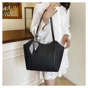 Elegant black lychee leather tote bag with silk scarf detail shown on a model
