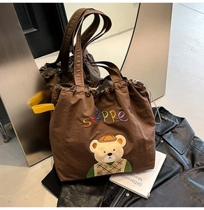 Detail of canvas tote bag with Steppe embroidery and cute bear patch on leather jacket
