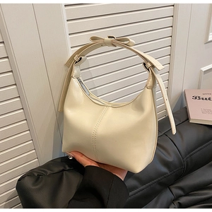 Détail du sac hobo avec poignée à nœud et fermeture éclair en métal poli blanc crème