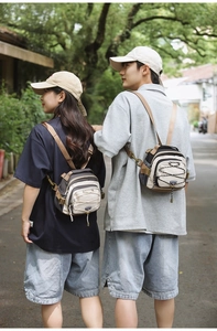 Outdoor shot of models carrying minimalist canvas crossbody bags with drawstring mesh detail