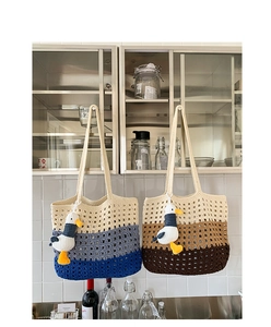 Detail of hand-knitted crochet tote bags with plush animal charms on cabinet handles